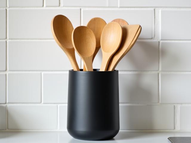 Matte black ceramic utensil holder with wooden kitchen tools